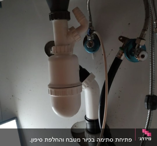 צנרת פלסטיק לבנה מתחת לכיור עם ברזים